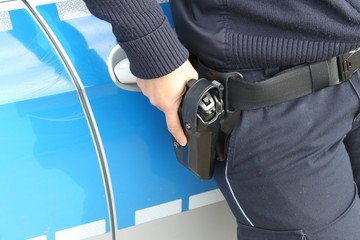 Polizei bei Kontrolle mit Hand an der Waffe