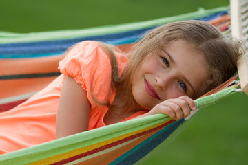 Fototapeta na wymiar Odpoczynek w ogrodzie - piękne dziewczyny w kolorowe hamaku