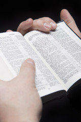 closeup of the hands of a man holding russian bible