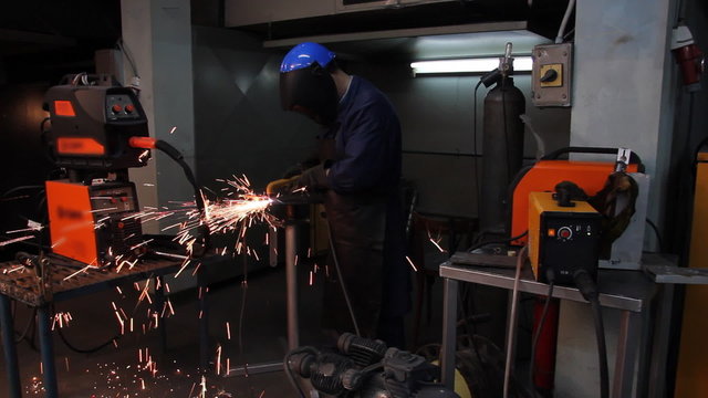 Worker cutting steel in a workshop