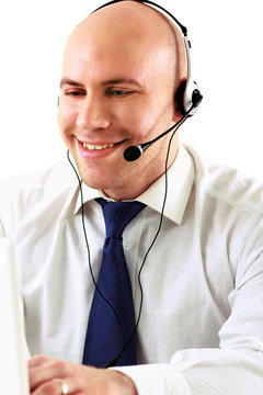 A call center employee sitting with a laptop and a headset