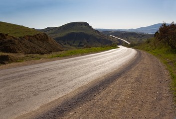 asphalt road turn in a sunny valley