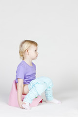 little girl using potty - obrazy, fototapety, plakaty