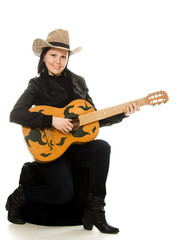 cowgirl in ahat with acoustic guitar