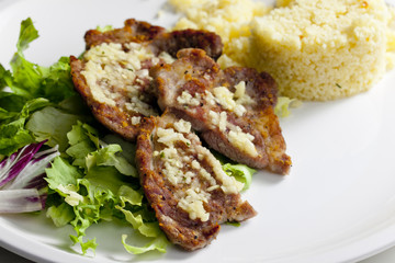 grilled pork neck on garlic with couscous