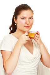 A young woman witn a cup of tea in her hands, isolated on white