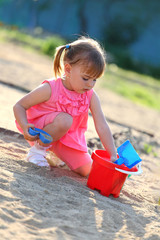 Girl playing alone in the sandpit