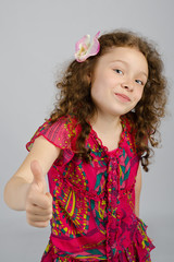 Portrait of smiling little girl with thumb up