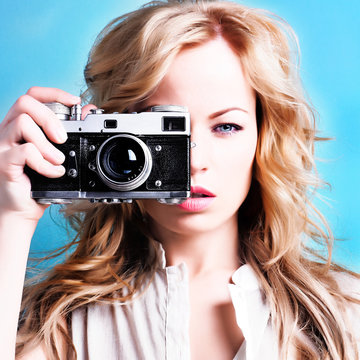 beautiful blond photographer woman holding retro camera