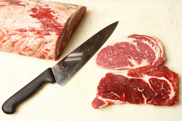Raw meat with a knife and cut pieces of meat
