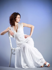 Fototapeta premium Young woman in retro bridal dress on blue background.