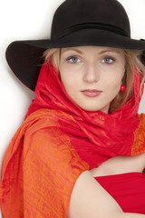 Young beautiful  blonde woman in a  blsck hat with a red scarf