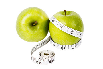Dieting concept Green apples with measuring tape
