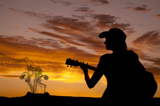 Silhouette woman guitar by fire