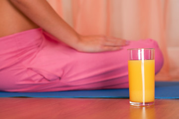 Glass of orange juice in front of sporty woman