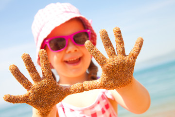 little girl play jn sandy beach - Powered by Adobe