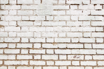Old weathered brick wall white paint close up.