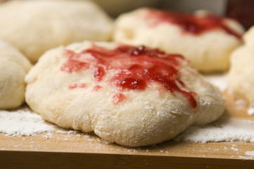 Dough with marmelade on wooden board