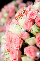 wedding rings of the groom and the bride on a bunch of flowers.