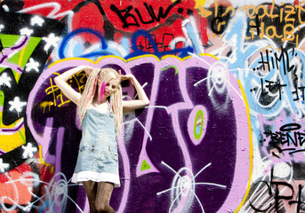 young woman standing at graffitti wall