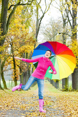 woman with an umbrella in autumnal alley