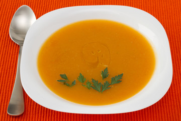 pumpkin soup with parsley in white plate