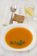pumpkin soup with parsley in white plate