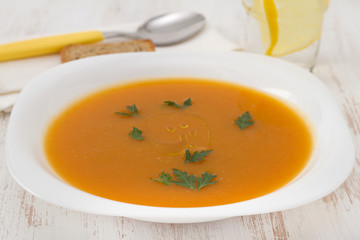 pumpkin soup with parsley in white plate