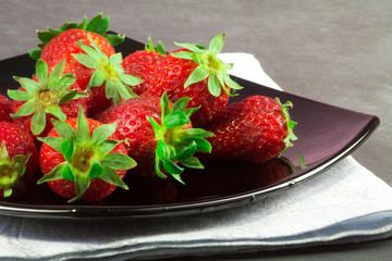 fresh strawberry over black plate
