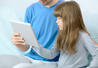 Father and daughter looking at digital tablet