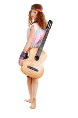 woman in hippie outfit walking with guitar