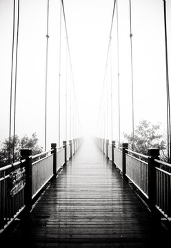 Fototapeta view on pedestrian wooden bridge in mist