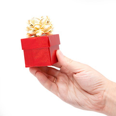 hand is holding single red gift box with silver-beige ribbon