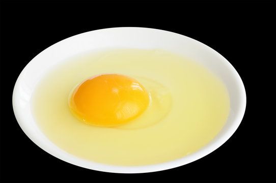 Egg in a white plate on black background
