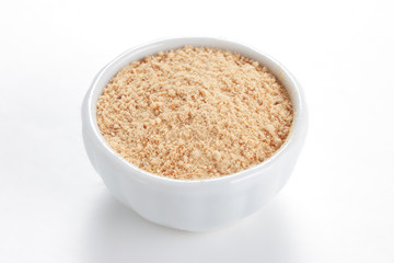 Ground Ginger (Zingiber officinale) in a white bowl on white bac