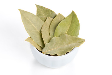 Bay Leaves in a white bowl on white background.