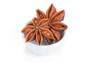 Anise star (Illicium verum)  in a white bowl on white background