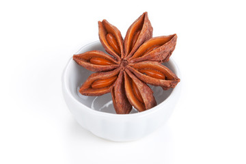 Anise star (Illicium verum)  in a white bowl on white background