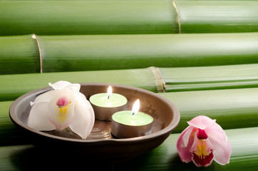 Obraz na płótnie Canvas Cymbidium kwiaty i świece herbaty na bambus