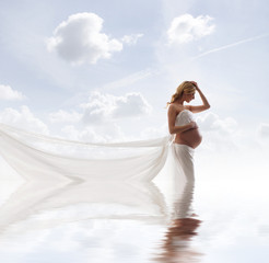 Fototapeta na wymiar A young blond pregnant woman in white bride clothes