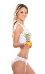 A young and sexy blond woman holding a fresh fruits