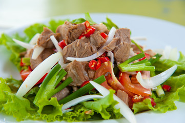 Spicy salad with pork and green herb in Thai style