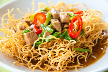 Chinese style deep fried yellow noodles with pork and soup