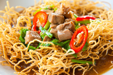 Chinese style deep fried yellow noodles with pork and soup