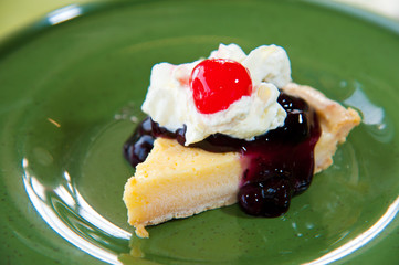 blueberry cheesecake with cream and red jelly