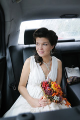 Beautiful young bride portrait in a car