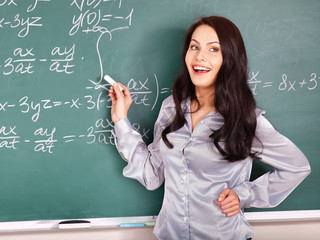 Schoolchild writing on blackboard.