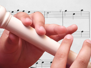 Child playing on white recorder
