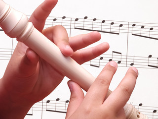 Child playing on white recorder