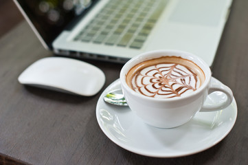 Laptop with coffee cup on wood table